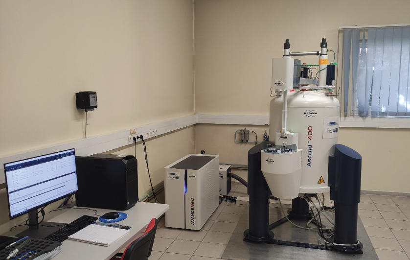 Photographie prise dans un laboratoire montrant un spectromètre RMN Advance 400 MHz Bruker connecté à une console et à un ordinateur pour le traitement et l’acquisition du signal. Image clicable donnant accès au descriptif de la RMN 400 MHz.